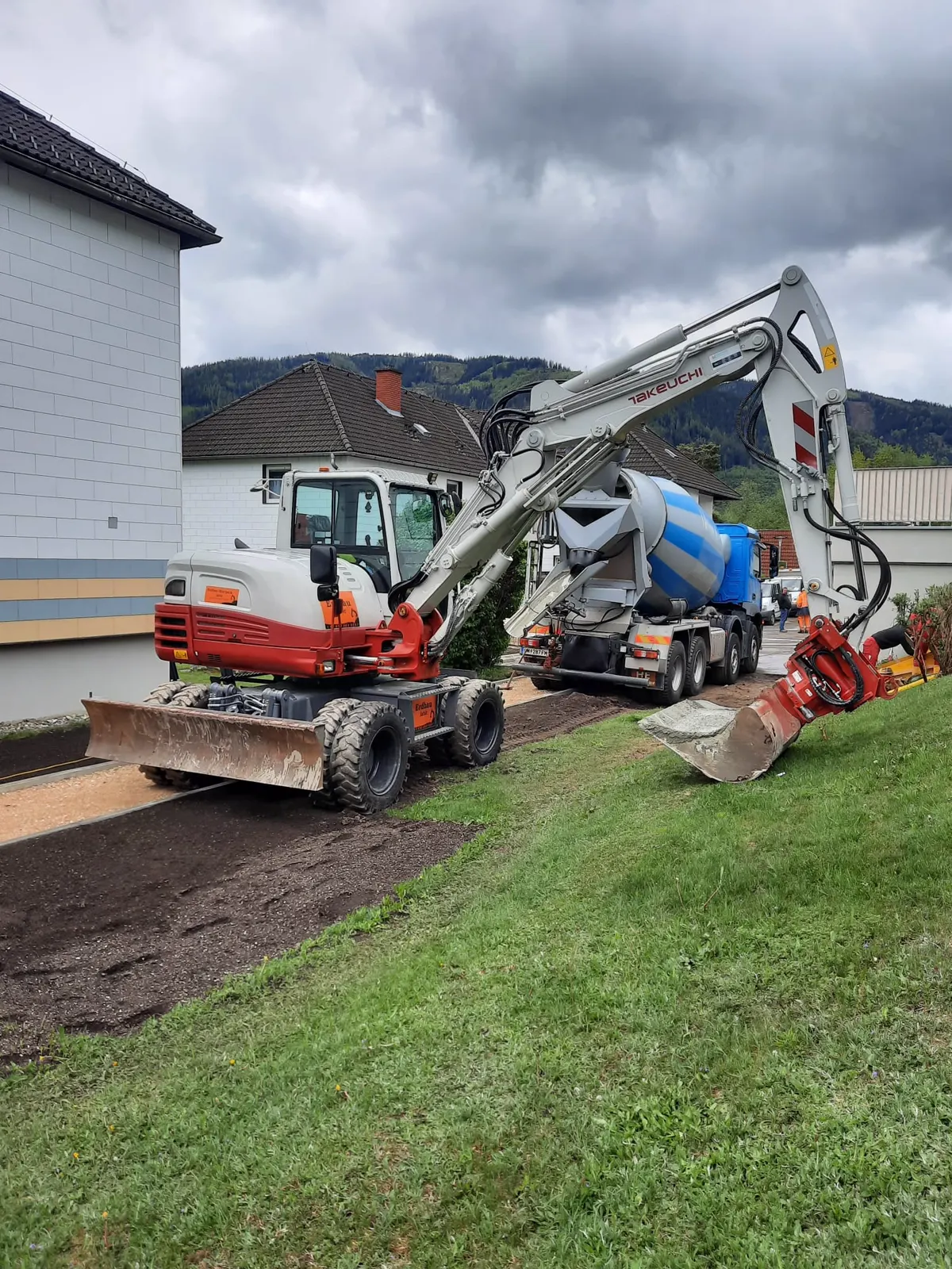 Bagger und Betonmischer beim Hausbau